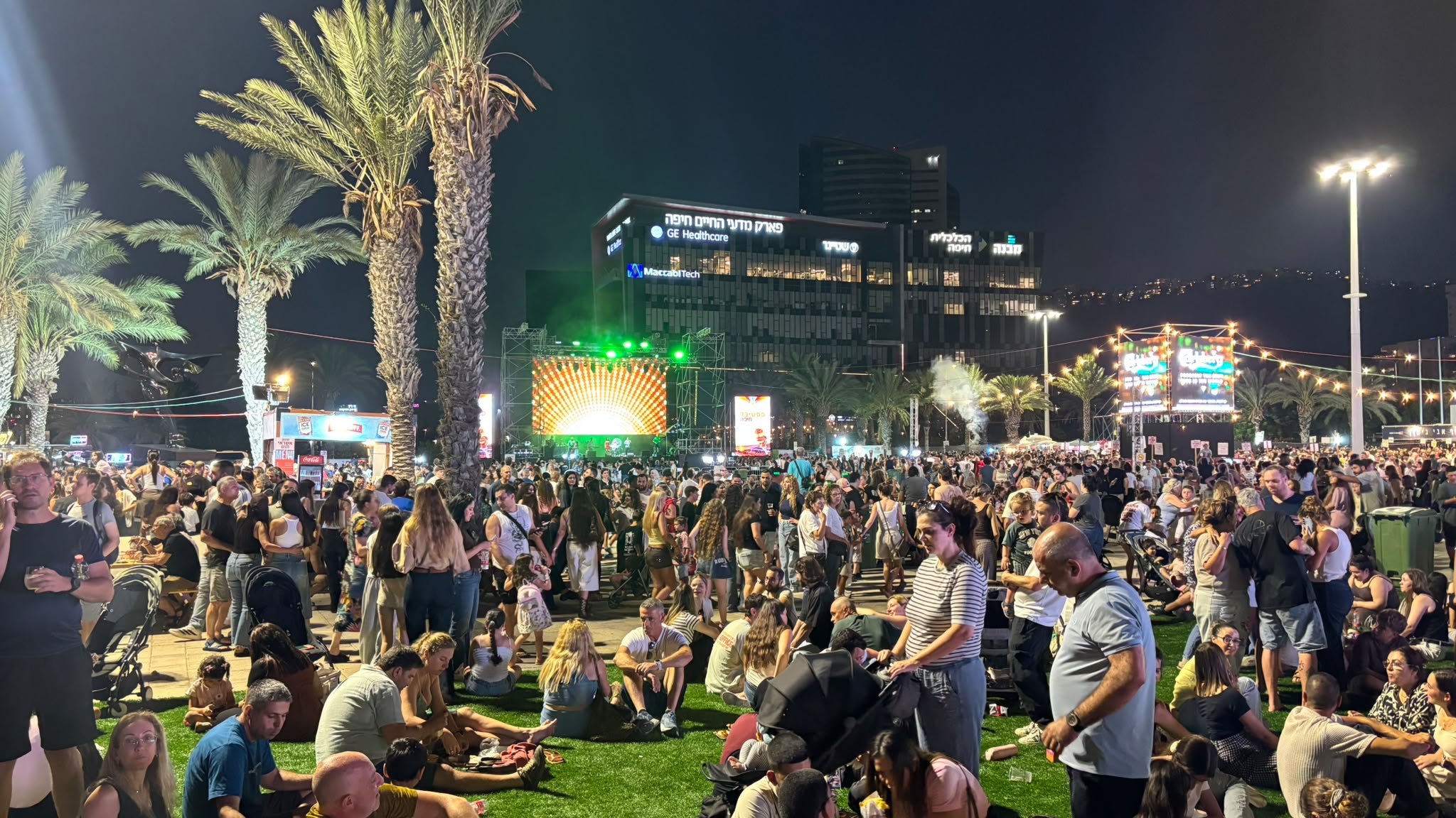 משפחות חוגגות על הדשא בפסטיבל האוכל בחיפה